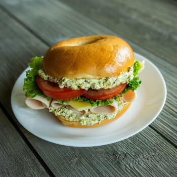 Sourdough bagel sandwich with turkey, pesto, and swiss cheese